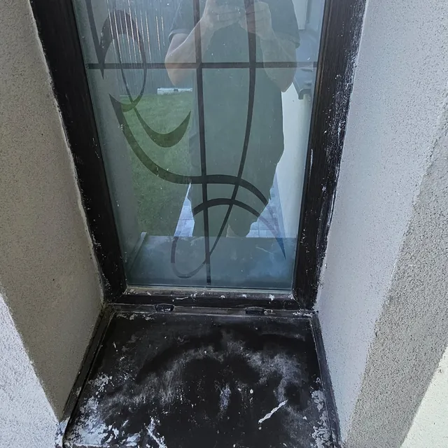 Geam și glaf murdare de vopsea și praf, înainte de curățare